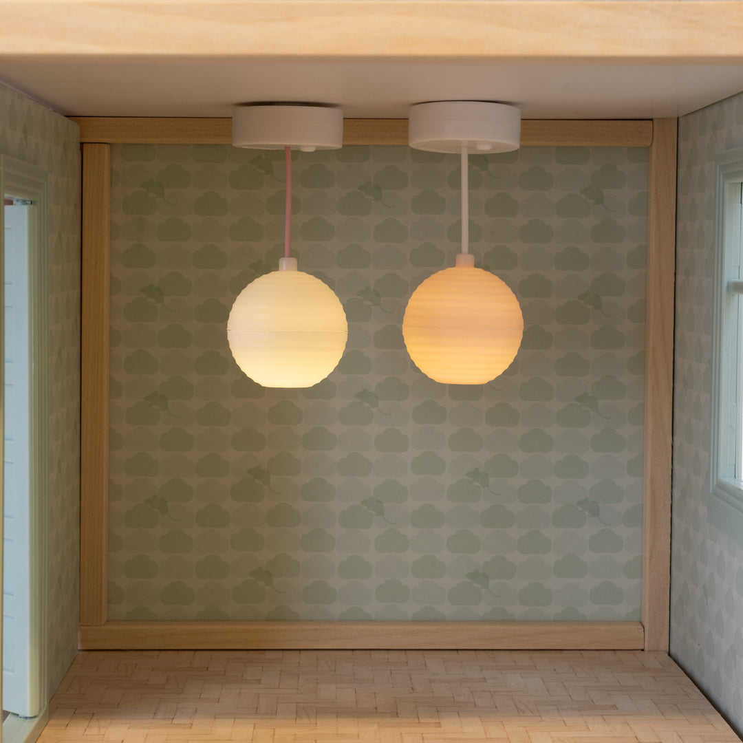 Lundby battery-powered LED dolls house lamps switched on, lighting an empty dolls house room.